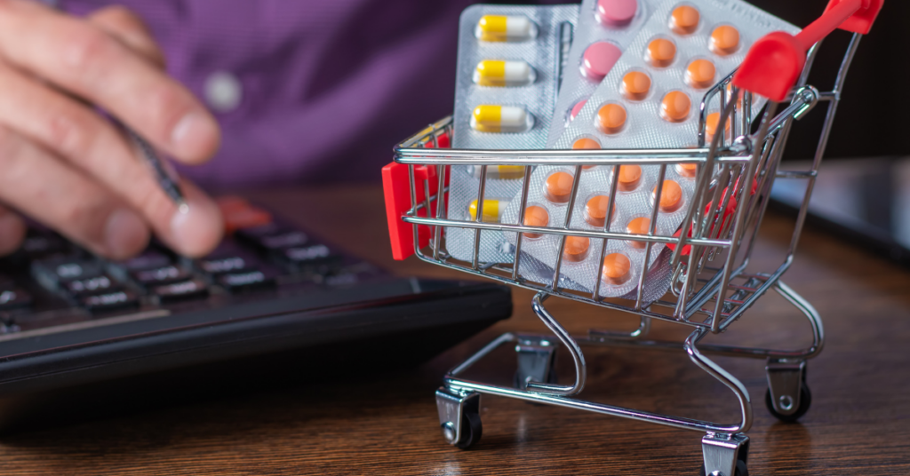 A small shopping cart filled with blister packs of pills, symbolizing the concept of purchasing medication