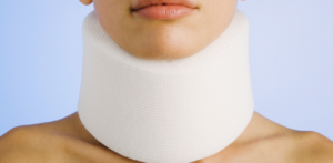 Close-up of a person's neck wearing a white cervical collar against a light blue background