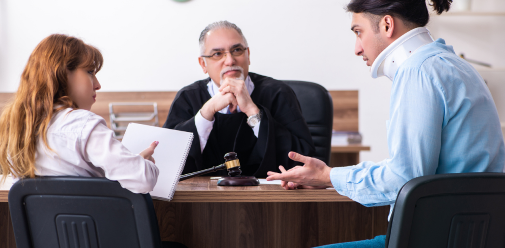 A courtroom scene where a man with a neck brace speaks with a lawyer, while a judge listens, indicating a legal case related to an injury