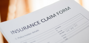 Close-up of a printed document titled Insurance Claim Form with fields for policyholder details