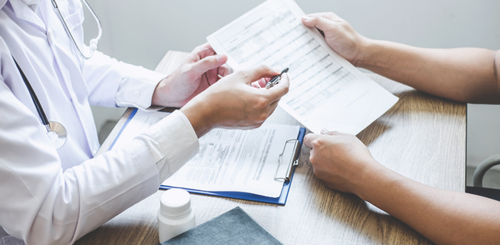 Doctor reviews medical records with patient, discussing treatment for personal injury case