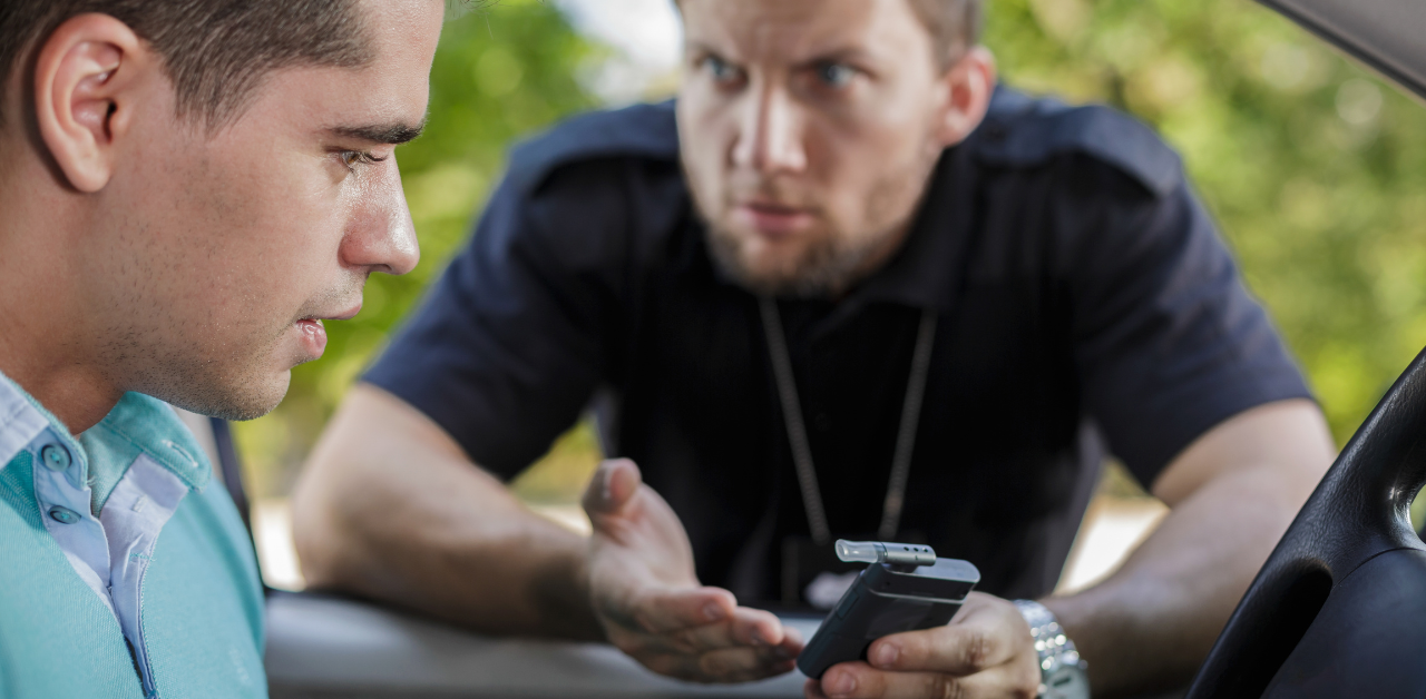 Police officer holding a breathalyzer, questioning a concerned driver during a roadside sobriety check