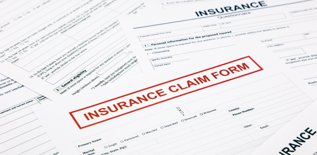Stack of insurance claim forms spread out on a table