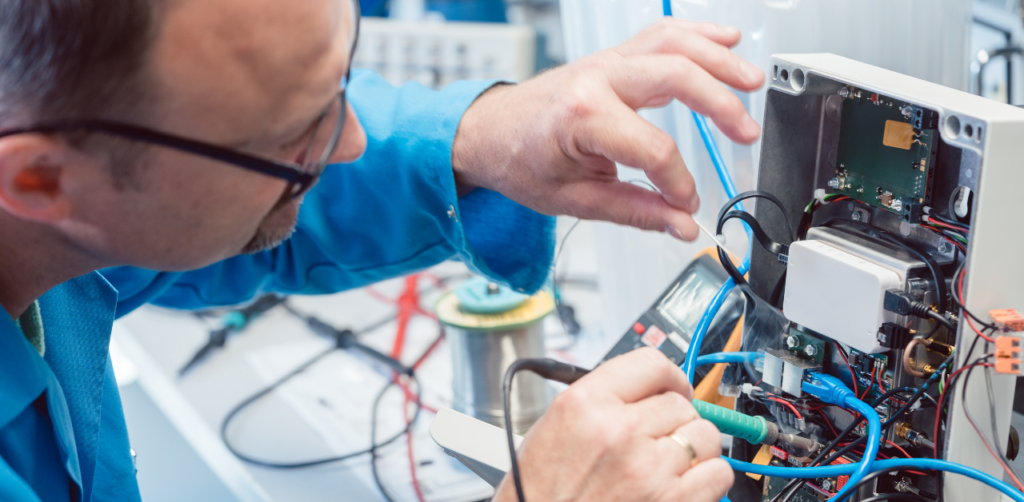 Technician inspecting internal wiring of an electronic appliance to troubleshoot a malfunction