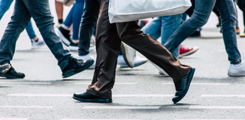 Pedestrians walking across crosswalk in busy city street, illustrating urban traffic flow and pedestrian movement