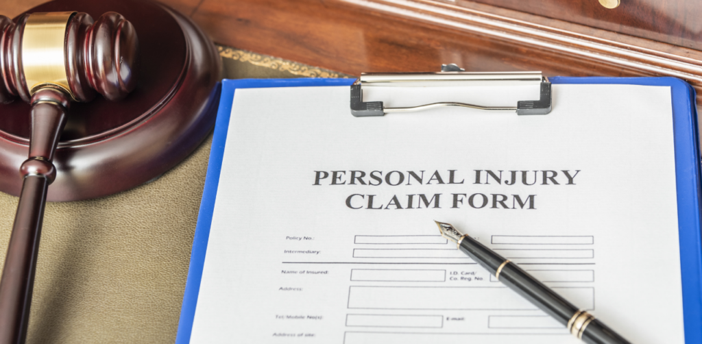 Personal injury claim form with gavel and pen, representing legal case filing and accident compensation process