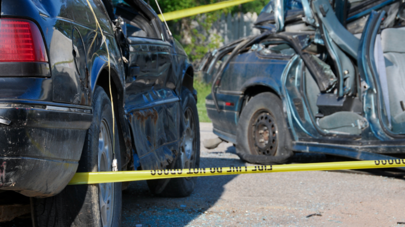 Severely wrecked cars behind caution tape, representing accident scenes linked to Casino Escalator Accident Claims
